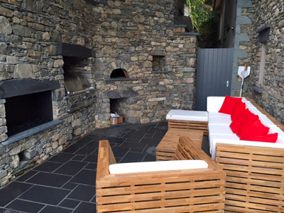 New rubble stone wall with gas fire, barbecue and pizza oven set in